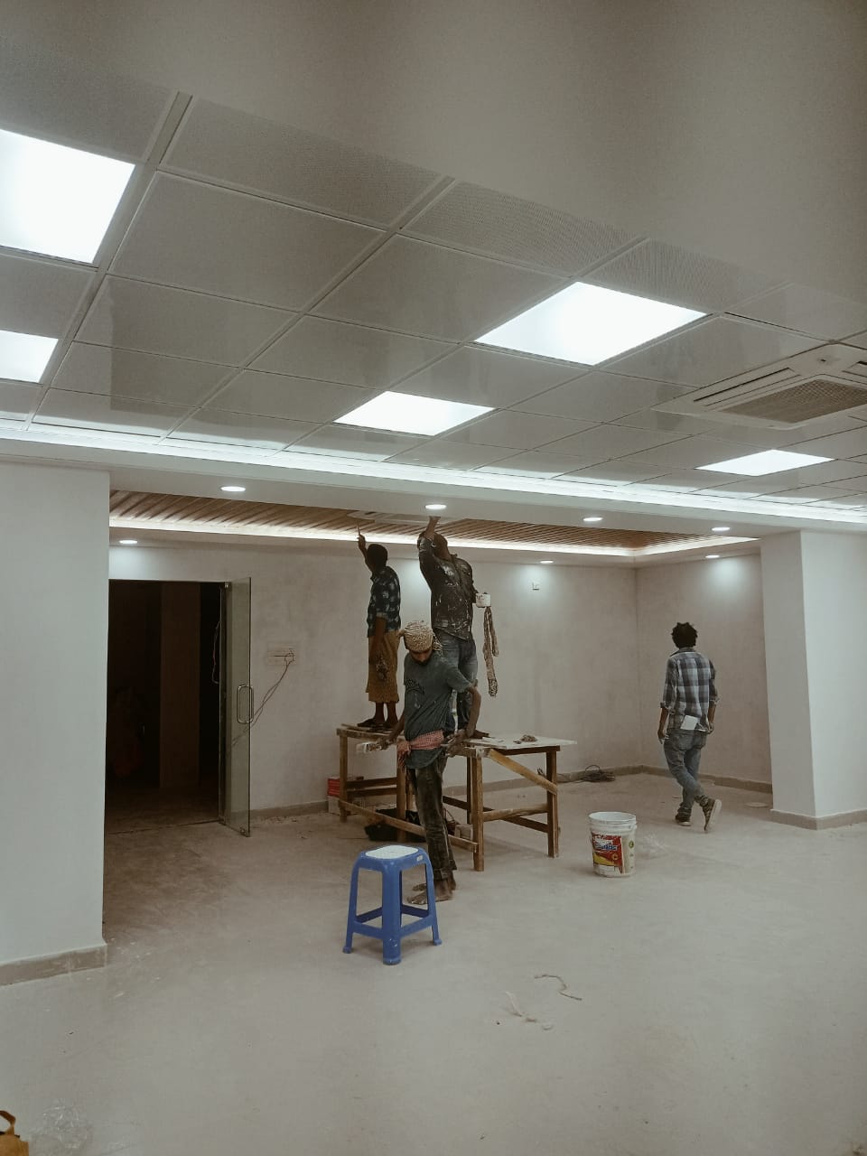 Open-plan office floor with a flush ceiling grid of panel lights during fit-out