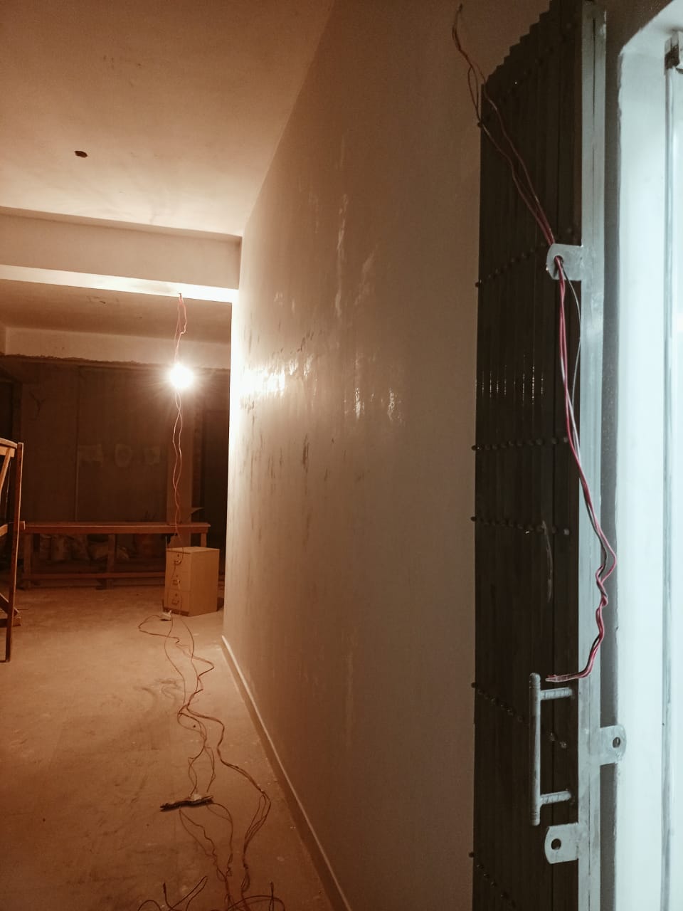 Corridor with boarded walls and cabling before ceiling and finish work